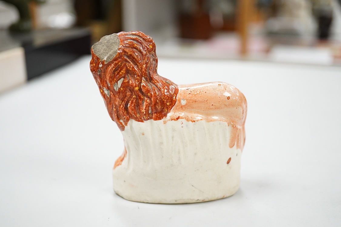 A rare Staffordshire Pearlware model of a recumbent lion, c.1810, and three Staffordshire pottery models of lions, mid 19th century, largest 11cm wide